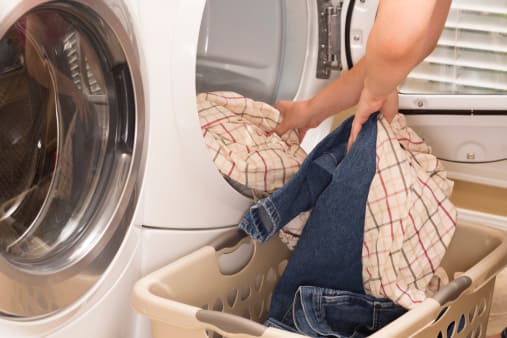 personne qui récupère le linge dans le sèche-linge